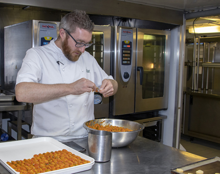 A Chef preparing peppers in the Galley. 