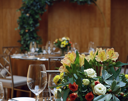 An arrangement of yellow and orange flowers on a table in Fingal's Ballroom.