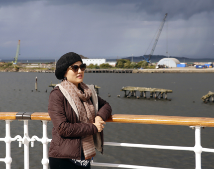 A woman visitor standing outside admiring the sea views.