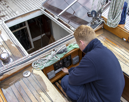 A member of the Maintenance team checking dials on the engine on ~Royal Racing Yacht Bloodhound. 