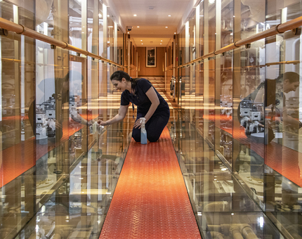 A member of Fingal's Housekeeping team polishing the glass walkway through the Engine Room. 