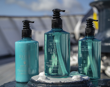 Two turquoise bottles of handwash and one bottle of hand lotion. 