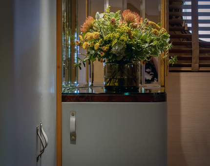 A vase of orange and yellow flowers on the minibar inside one of Fingal's luxury duplex cabins.