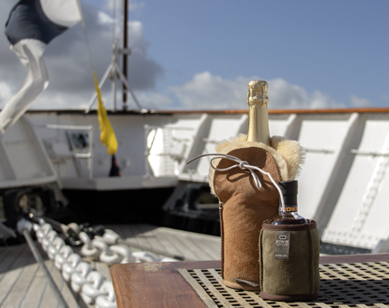 Two sheepskin champagne and wine coolers chilling bottles outside on deck. 