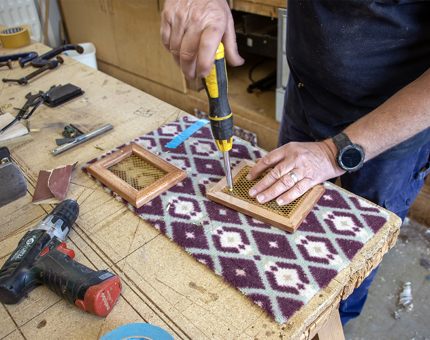 The Maintenance Team use a screwdriver to work on ventilation covers for Bloodhound. 