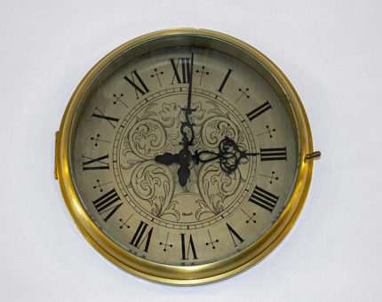 A clock with roman numerals on the face. The time is 3.01pm.