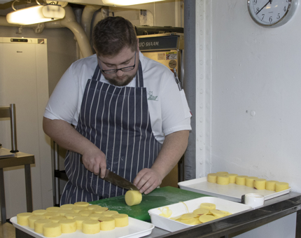 A Chef chops potatoes in the Galley. 