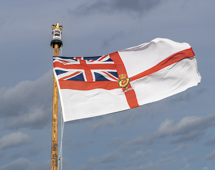 Britannia ensign flying in the wind on the ensign staff.