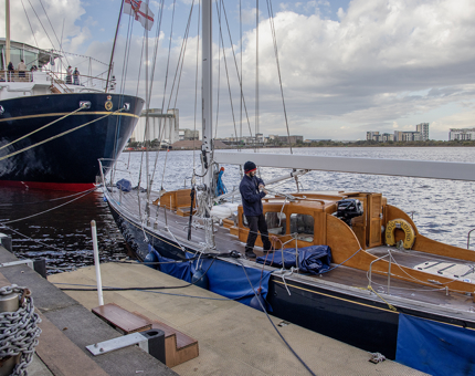 A man from Maintenance handles ropes and rigging on the racing yacht Bloodhound. 