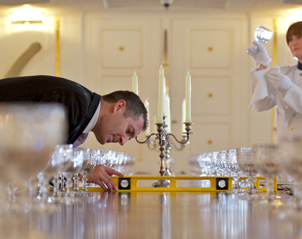 Two men setting a table in the State Dining Room. 