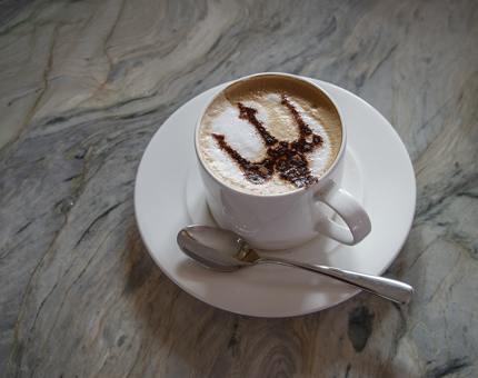 A cappuccino with Fingal's trident stencil on top.