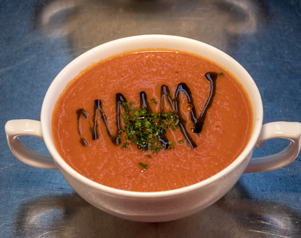 A bowl of tomato and red pepper soup. 