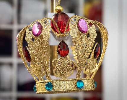 A decorative hanging crown ornament containing brightly coloured stones. 