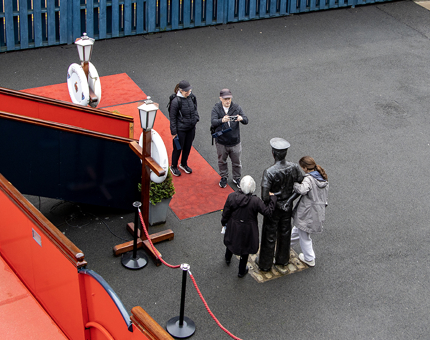 Visitors pose next to the life-size statue of a former Royal Yachtsman on Britannia's Quayside. 