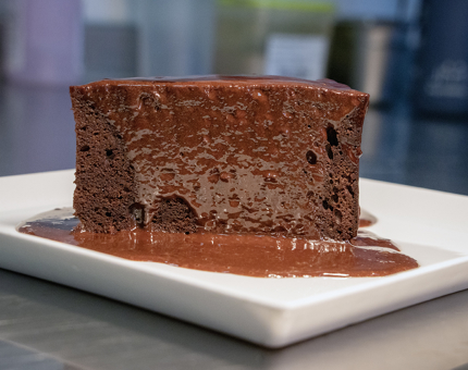 A slice of chocolate fudge cake on a plate. 