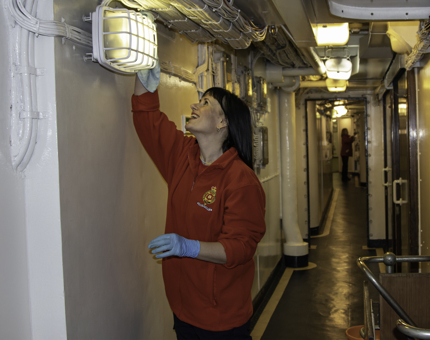 Two Housekeepers at Britannia cleaning an inside corridor of the ship. 