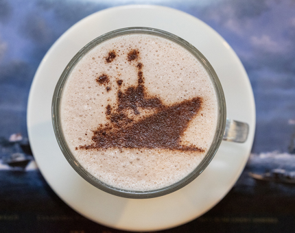 A hot chocolate with a chocolate Britannia ship's stencil on top. 
