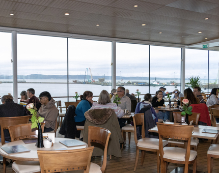 A busy Royal Deck Tearoom with tables of visitors enjoying drinks and light bites. 