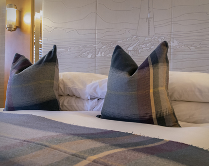 A cabin aboard Fingal with purple and blue tartan pillows.