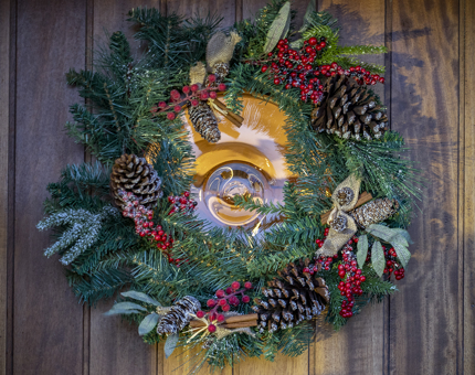 A festive wreath of fir, red berries and pine cones hanging on the front door at Fingal. 