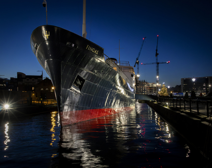 The exterior of Fingal with a lit Christmas Tree at nighttime. 