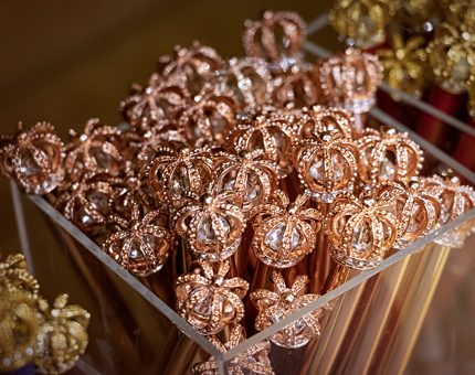 A display box filled with gold crown topper pencils.