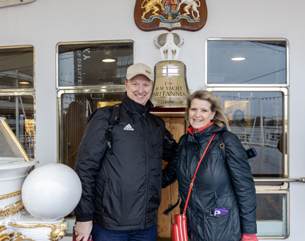 A man and a woman stand next to Britannia's Bell. 