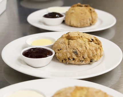 Plates of scones with jam and clotted cream. 