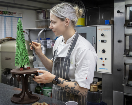 A Chef adds chocolate baubles to a sculpture made entirely of chocolate.