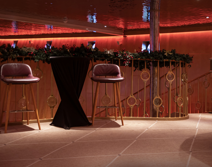 The Fingal Ballroom Bar with two bar stools and a garland-festooned balcony. 