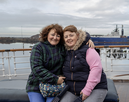 A couple pose in front of the waterfront at Leith Docks.