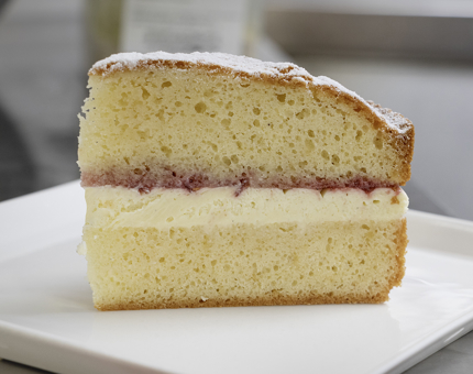 A large slice of Victoria sandwich cake.