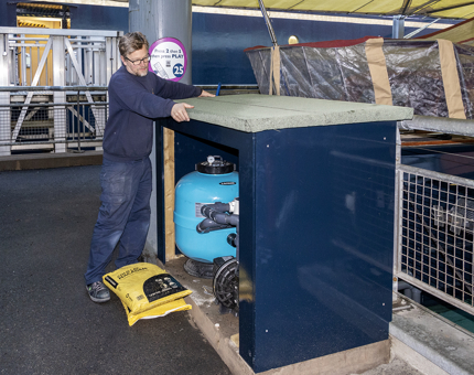 A member of the Maintenance team fitting a roof to a unit which houses the filtration unit.