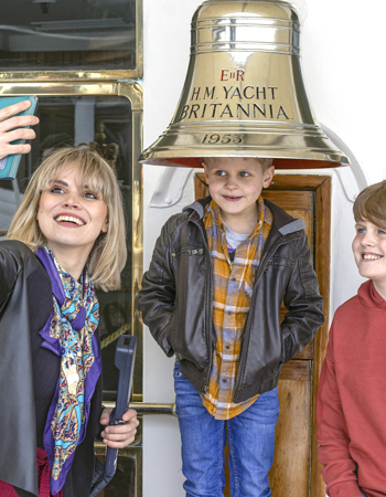 A woman and two boys take a selfie in front of Britannia's Bell. 