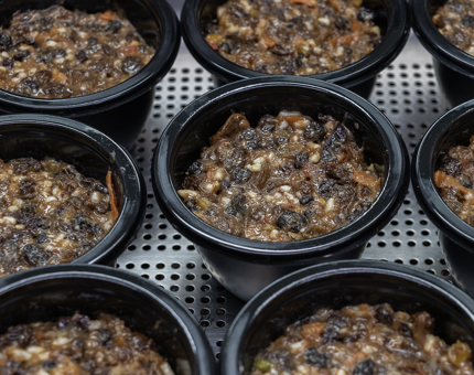 A tray containing Christmas puddings. 