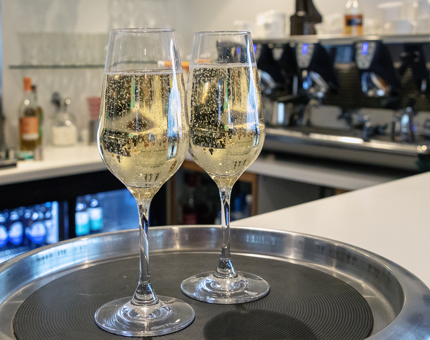 Two glasses of Champagne sitting on a tray at the bar in the Royal Deck Tearoom. 