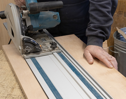 A man using a cutter machine in the workshop.