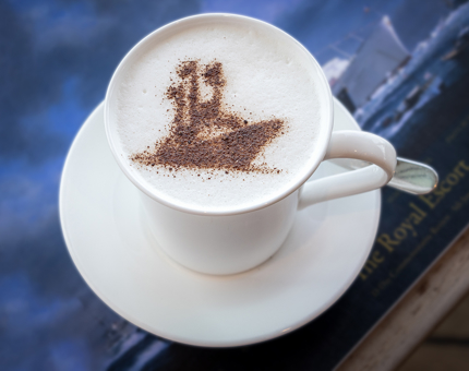 A cappuccino with a chocolate stencil of Britannia on top of the foam. 