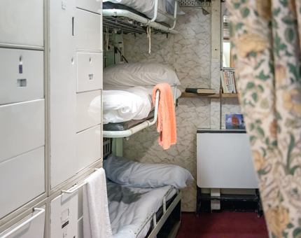 Inside the Royal Marines' bunks. There are two bunk beds and a bookshelf. 