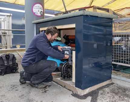 A man working in a box next to the Royal Barge filtration system. 