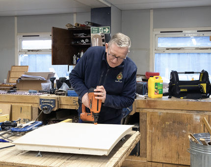 The man making the wooden hatch for the Fast Motor Launch.