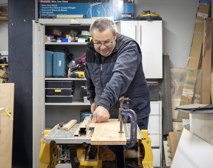A man using equipment in the workshop to make floor signage.