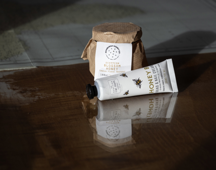 A honey jar and hand cream on a table 