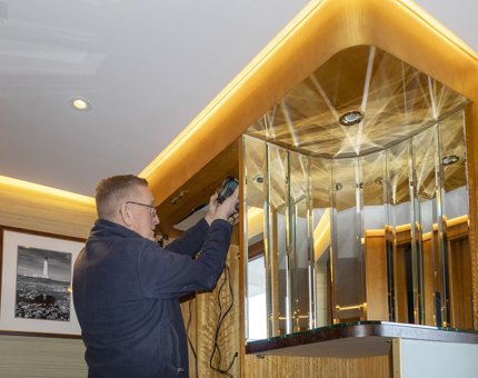 Man in blue jumper fixing mirror 