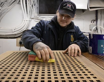 Man in blue coat working on a rope box 