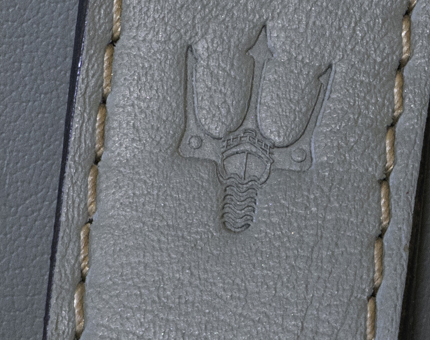 A detail of Fingal's logo of a trident and ship on the leather handle of a wardrobe in a cabin at Fingal.