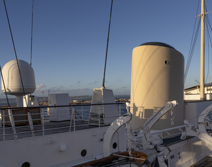 The top level of Britannia, the Bridge with the sun shining on the ship's funnel.
