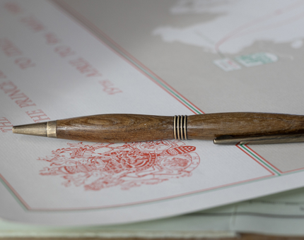 A pen made from tea resting on a document. 