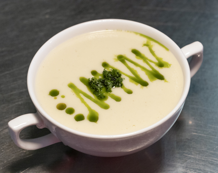 A two-handled bowl of cauliflower soup. 