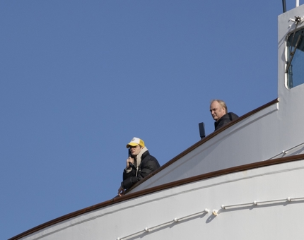 Two visitors listen to audio guided tour handsets on the Bridge. 